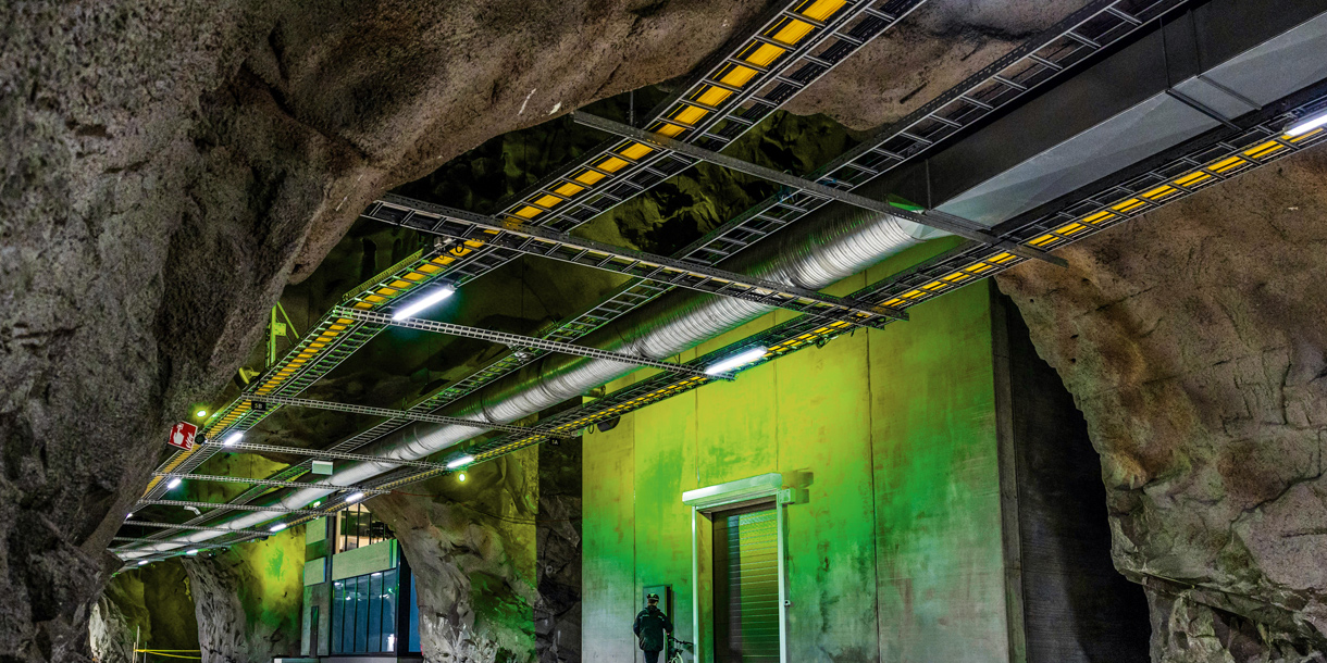 Underground industrial tunnel with pipes and lighting