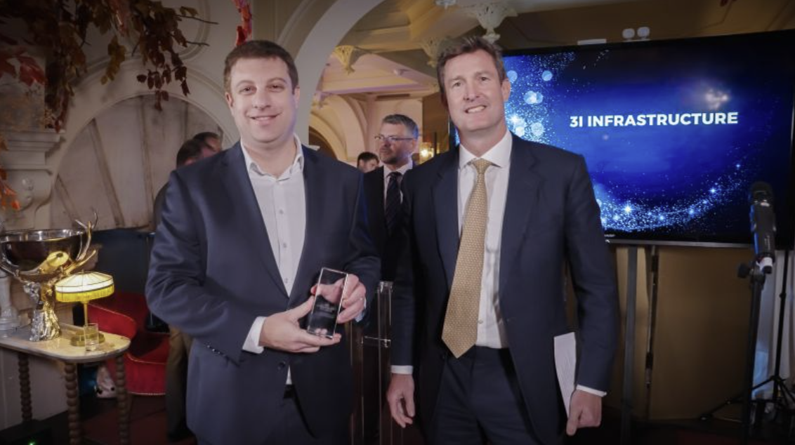 Two men in suits with an award trophy