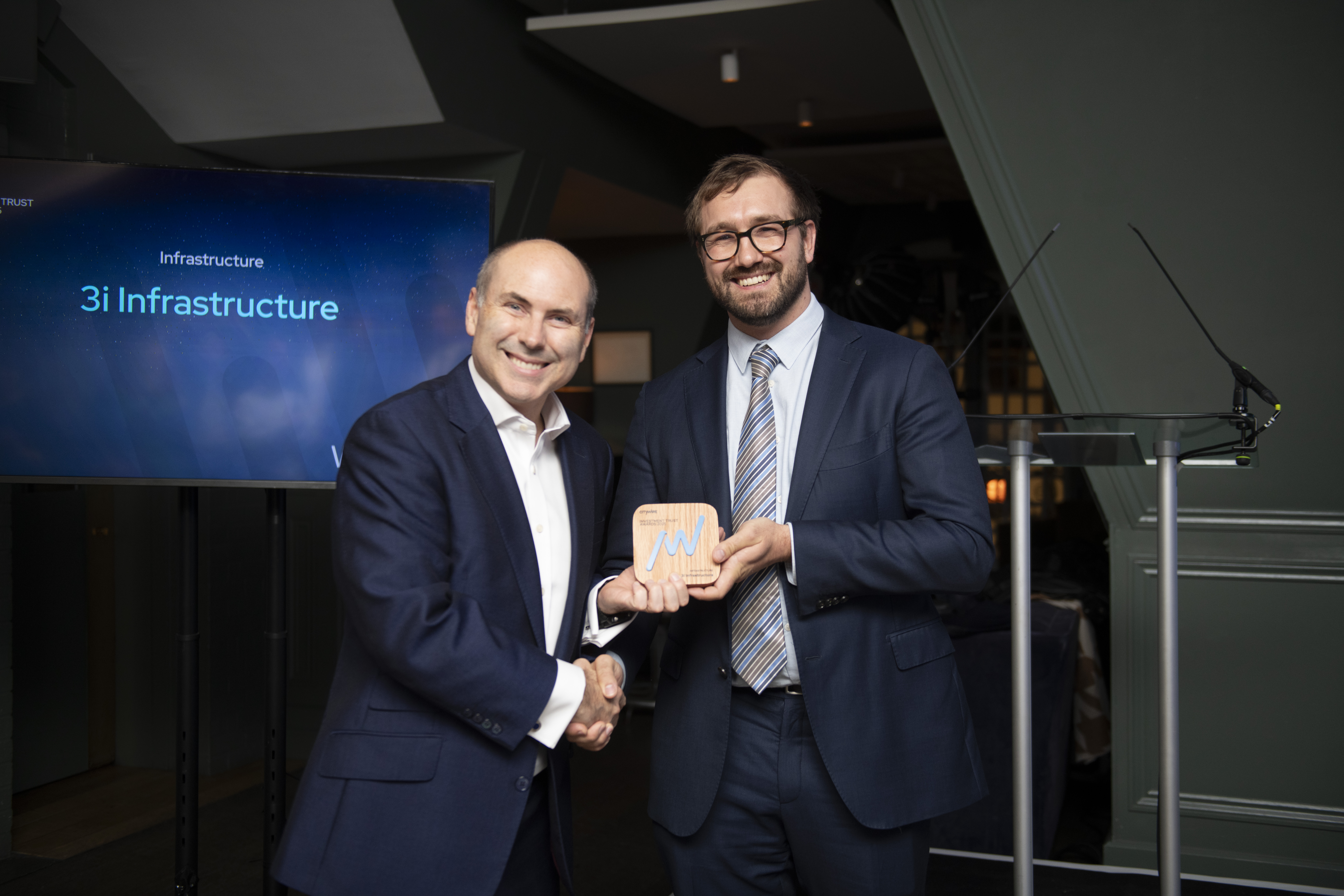 Two men in suits holding an award  at the Citywire Investment Trust Awards 2025